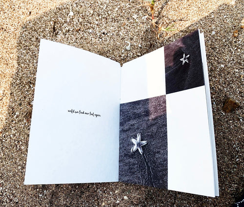 Open spread on sand — left page with small text, right page with black and white photographs of starfish on dark beach